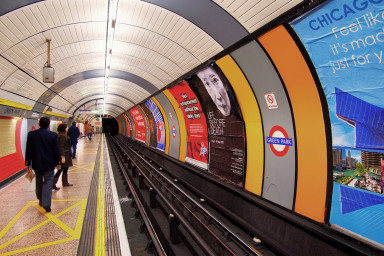 Image of a London Underground station, with advertisements on the walls