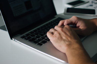 A landscape photo of a person using an apple macbook