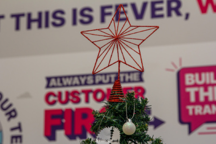 This is Fever - Red Christmas tree star with a board reading "this is fever" behind it.