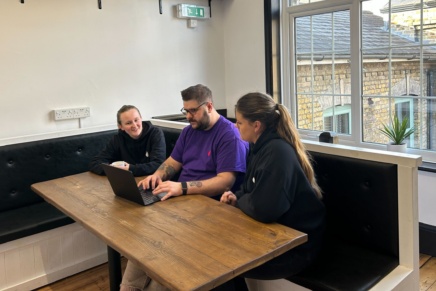 Three members of the This is Fever team working together on a laptop