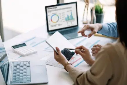 Two people viewing analytics and tracking data across a range of screens
